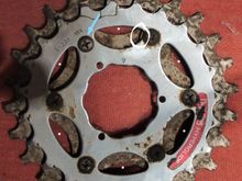 Top side of assembled sprockets
Blue Arrow:  cleaned-up bolt location to show countersinking and grinding down the bolt head to avoid fouling chain.
White circle: visible edge of stem-nut spacer