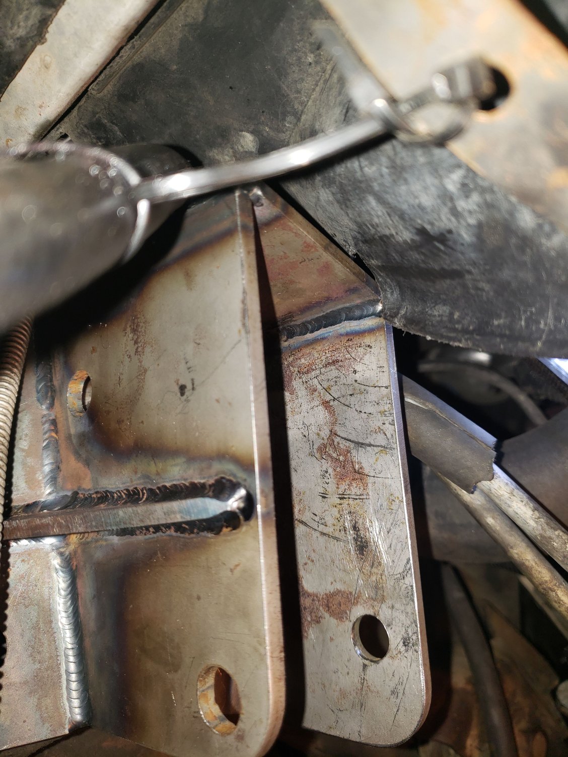 Where the bracket was touching the fan shroud. A hack-saw blade in a holder made short work of cutting a notch in the shroud.