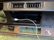 I will get a shorter, right-angle charging cord that will stay inside the compartment.