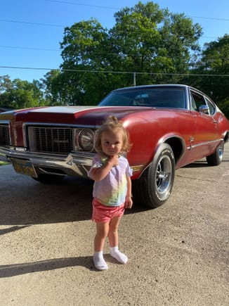 My 18 month old daughter in front of the car that will be given to her when she gets her license. 