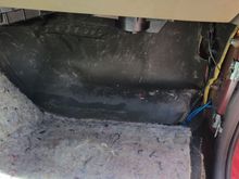 Passenger floorboard with carpet pulled back.