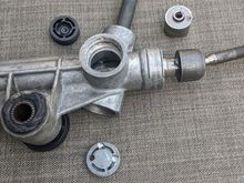 When you get the plastic cover off the side of the receiver, remove the drivers side bushing. Under the metal cap at the bottom there's a roller bearing at the bottom of the input shaft and it's retained by a c-clip. Don't remove the c-clip (unless the bearing is damaged and you need to replace it).