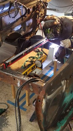 Here is Stephen welding it in. The wooden sticks have a hole set at the height I needed the cross member to be at. Worked great. The cross member is close to the motor mounts, so we need smaller torch cups to get it the tight space.