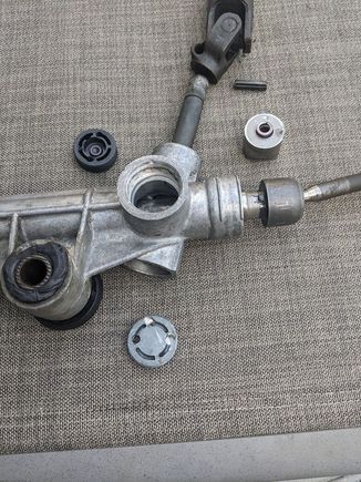 When you get the plastic cover off the side of the receiver, remove the drivers side bushing. Under the metal cap at the bottom there's a roller bearing at the bottom of the input shaft and it's retained by a c-clip. Don't remove the c-clip (unless the bearing is damaged and you need to replace it).