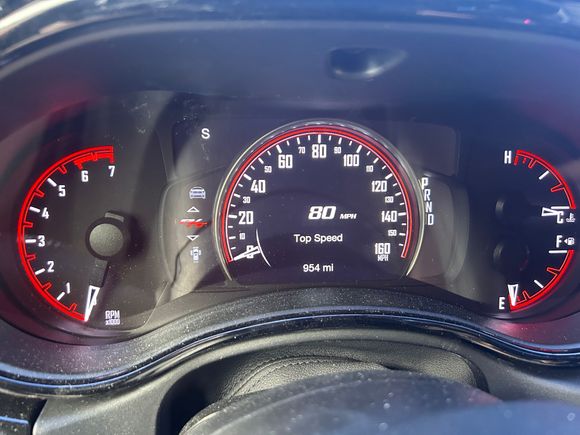 Anyone know the trick to get the digital speedometer to show up in the center of the speedo, like the top speed is showing in the picture? 