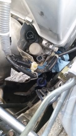 Here's your target. Place a towel under the solenoid to catch oil when its removed. Disconnect everything attached to the solenoid. I also detached a crank sensor, and the oil pressure sensor under the solenoid. Notice the wire tie on the right is not accessible from above. I didn't remove the heat shield, instead I cut the tie and replaced it with a  zip tie after