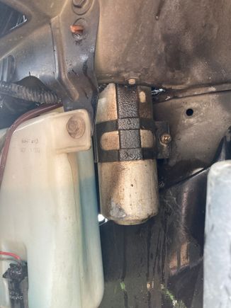 Peel back the inner fender liner and see the clamp holding the dryer in place