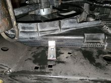 Aluminum bar stock bent (like a double L, or flattened out Z) and bolted to bottom cross member on each side with slots cut in shroud to hold it against the radiator. The shroud assembly sits perfectly on the cross member which holds its weight, and the seal perfectly fills all gaps.