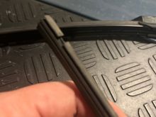 Looks like the plastic tabs engage the little rubber cutout. 1cm from end. 3mm wide. 