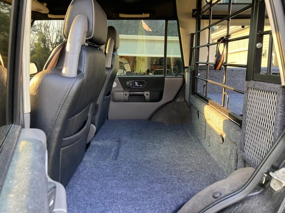 Rear seat area now a padded dog area. Speaker grilles in place. Cubbies below cage are large enough to hold two gallons of water each plus some.