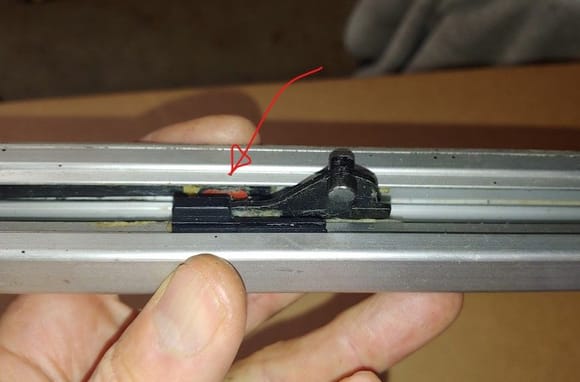 The arrow points to the square track bushing, the pin on the cable boss runs in one and the pin in the glass carrier runs in the other (not shown).  90% of the time the pin on the cable boss breaks off.