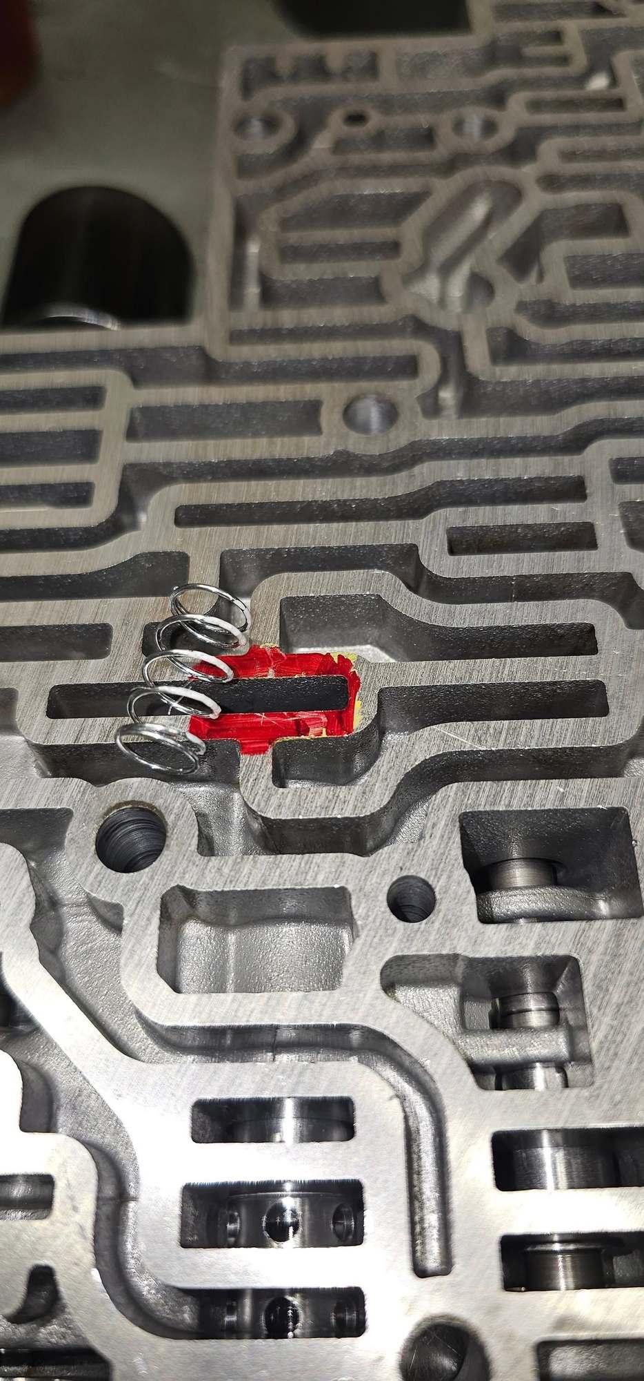 Spring over spot its goes. First look into th slot and use screw driver to push the isolator valbe away from bore wall 