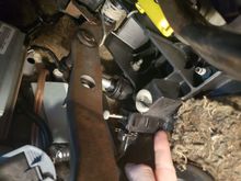 Pressing in the tab furthest away from the clutch pedal releases this switch from the bracket holding it.