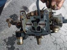 The piece lays underneath the carb