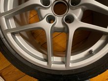 Thin scratch in lower outer portion of rear wheel