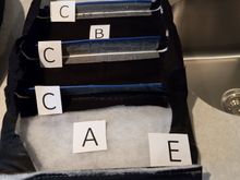 The rear side of the seat back center.  It has a number of attachment points.   So it isn't just draped over the seat back center.   