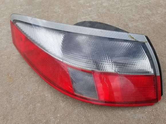 Left rear red grey tailight, note chip and crack. Used as spare for inevitable...175$ + shipping 
