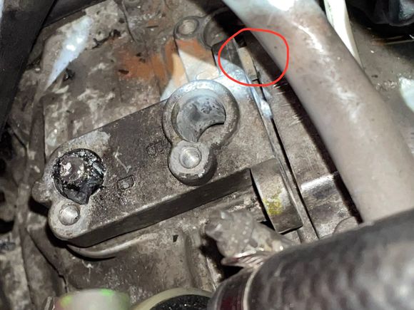 The remains of the speed sensor on the left. The positioning collar between the sensor holder and crankcase in the red circle. With the remains of the speed sensor sticking into the bellhousing, the bracket was not going anywhere without splitting the bellhousing and crankcase.