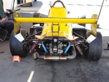 Formula Mazda in yellow, from rear.