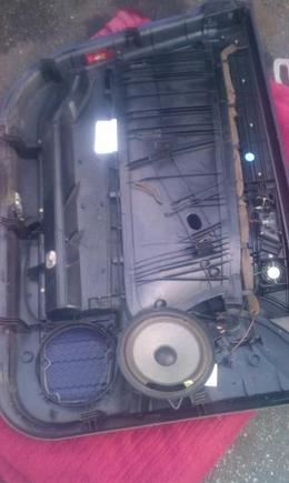 Door panel removed. There are other write ups on removing the door panel. It is not difficult. Do the passenger side first. Keep the window up. If it rains or you need drive you can shut the door and go. To lock car manipulate door lock cable with door shut.  Remove screws on rear end and front end of panel. Release window switch and plug. Gently lift door panel. Release lock cable and other plugs. Look them closely for release method, no need to force. Clips can be on side or depress center clip. Do not break clips.