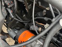 Coil harness with wire loom routed behind dipstick tube. You can also see the flat bracket attached to the stud that holds the ignition capacitor (little black box). 