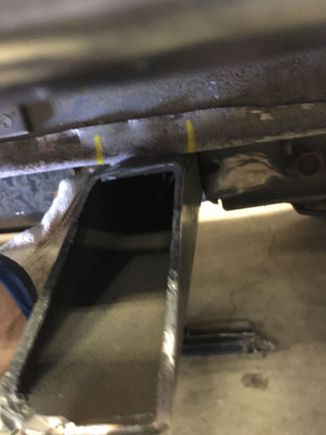 Start at the rear mount. Hold the tie in against the spring mount bracket, then mark the floor.