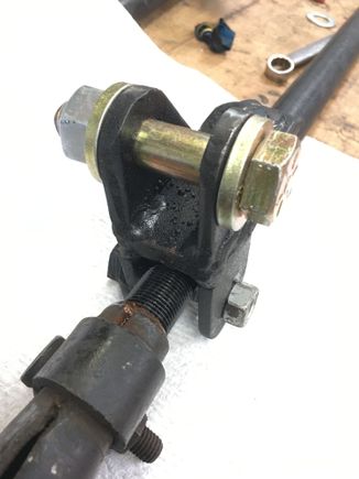 I don’t have build pics but I used a steering stabilizer stud with the straight wall end cut off, drilled and welded it into a 5/16” plate piece, then welded the tabs to it. On the other side I put another set of tabs and fashioned a cam bolt at arrangement so I could tighten the bracket snug against the drag link.