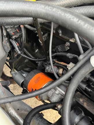 Coil harness with wire loom routed behind dipstick tube. You can also see the flat bracket attached to the stud that holds the ignition capacitor (little black box). 