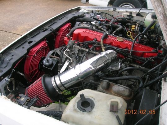 heres my engine, i cleaned this up quite a bit as well.  i added the electric fans and cold air intake to free up some horsepower and MPGs, i painted the valve cover, thermostat housing, water pump, and timing chain cover (replaced timing chain too) red just for the hell of it.