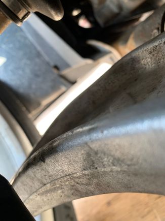 And here between the swaybar and LCA , the black area lower left of the photo 