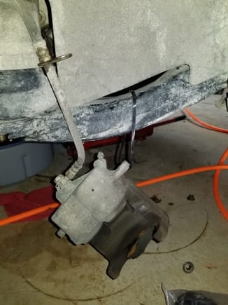 Suspend caliper from front subframe using ziptie or bungee cord.  I prefer zipties so I know there is no possible way it can come loose.