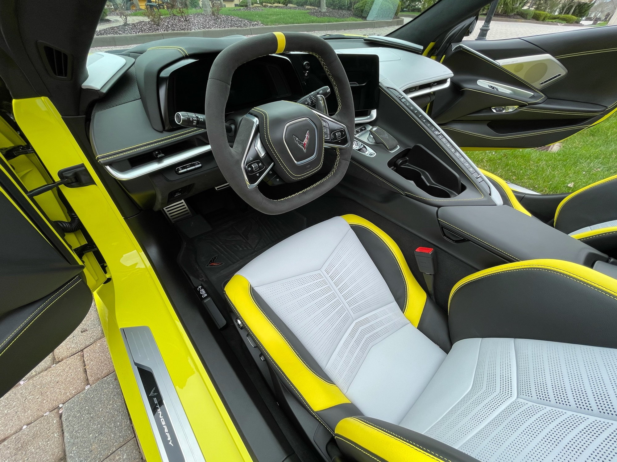 Interior gris celeste con cinturones de seguridad y costuras en amarillo llamativo Corvette C8