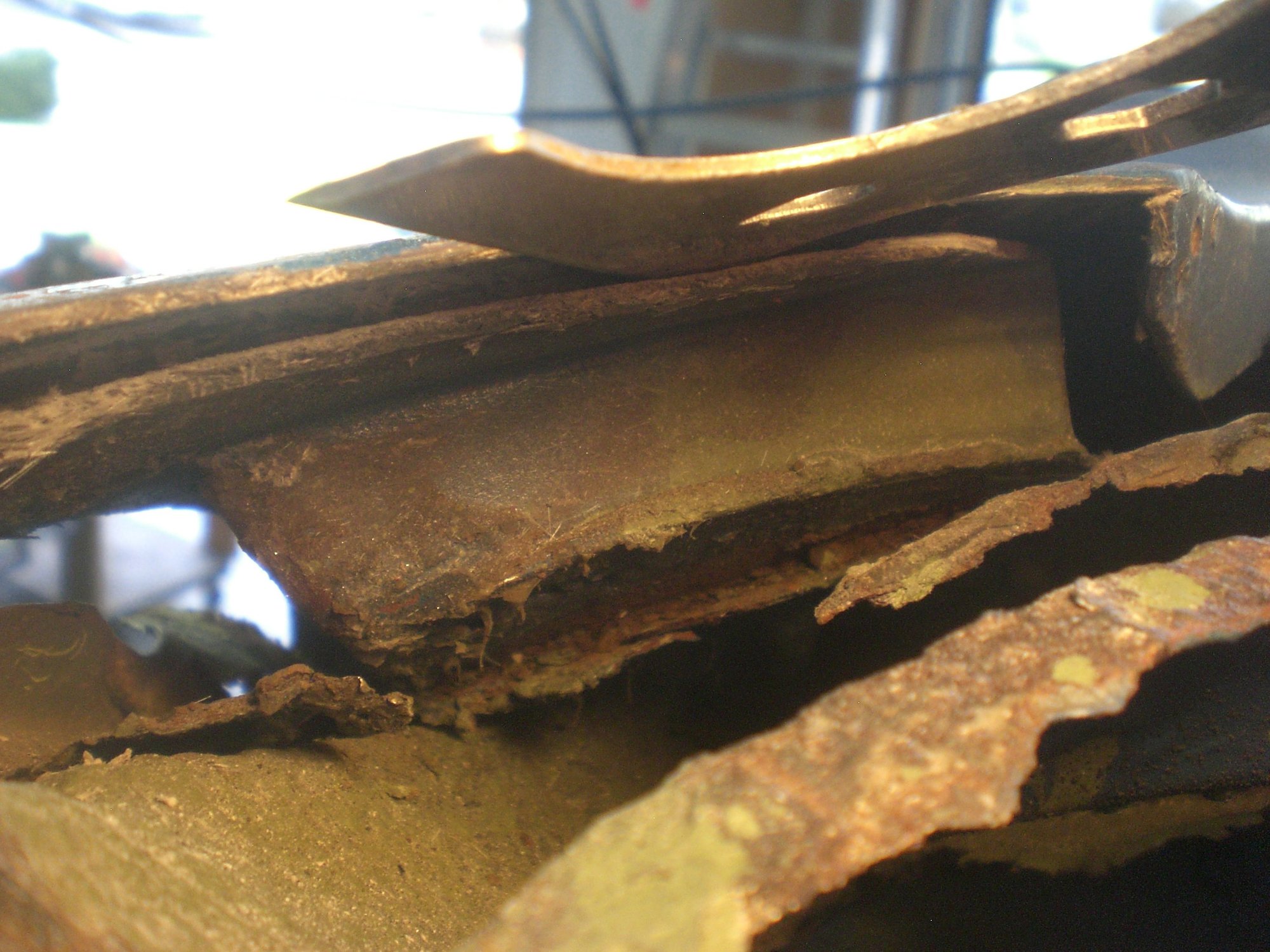 Left lower windshield frame inner & outer corners were badly rusted.  Here the outer fender skin is being separated from its underneath bonding support panel.