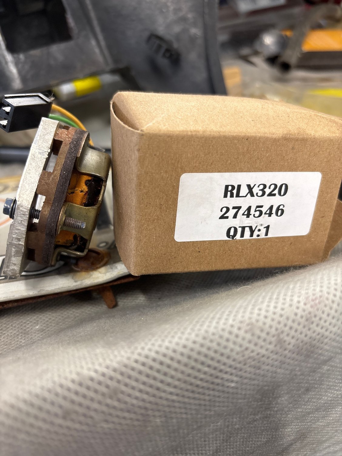 Old pickup coil unit next to new box from CC