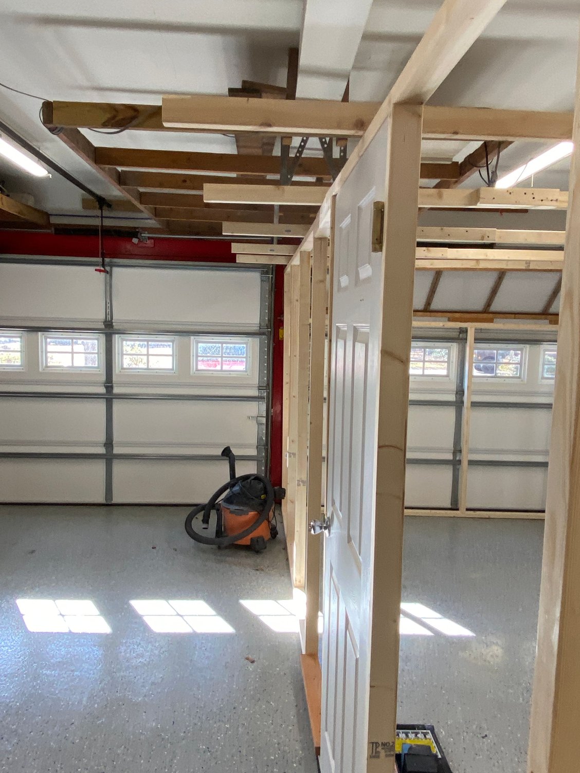 The ceiling joists overhanging the sidewall. On paint day I can slide the wall out to the end of the joists, giving me an extra 2' inside the booth