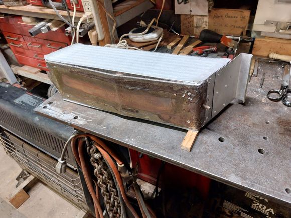 Pop riveted to original pan and added a restraint to hook over the storage divider. No additional holes nor attachments to the body.