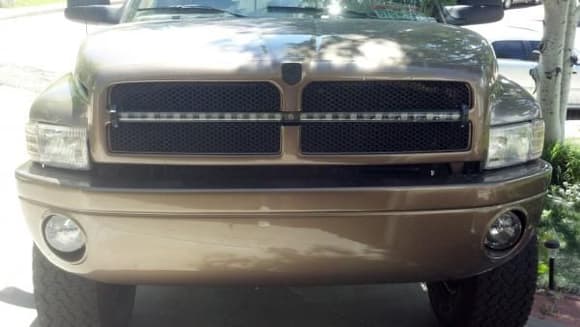 Painted bumper and grille, custom mounted LED lightbar and Lightforce HID's, and a custom Cummins grille emblem.