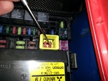 1) Pull up gently on this yellow box.  It'll pop up from the fuse box, but won't come out completely.
2) Using needle nose pliers, gently grab each fuse and wiggle them with a slight twisting motion.  The grabbers will give and you can then pull them out.