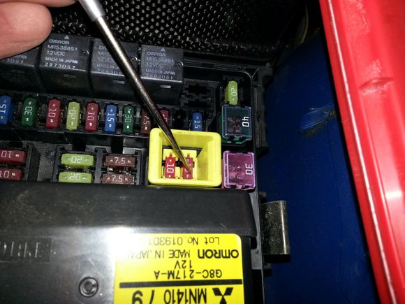 1) Pull up gently on this yellow box.  It'll pop up from the fuse box, but won't come out completely.
2) Using needle nose pliers, gently grab each fuse and wiggle them with a slight twisting motion.  The grabbers will give and you can then pull them out.