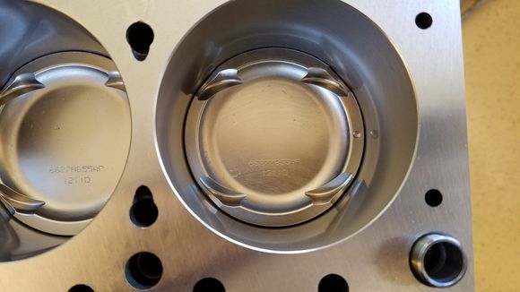 Valve reliefs of the Wiseco HD 1400 piston.  I believe the dot on each pistons represents timing side placement?