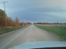 Driving down a dirt road. Another hundred feet down the road, on the left you'd see an oil well in the backyard of a house.