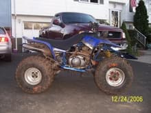 My old fourwheeler that i never should have sold, with dads truck in the background