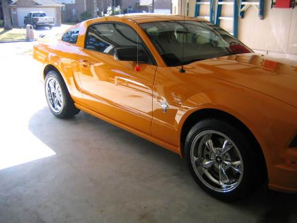 Car off jack stands with new rim and tire package installed.