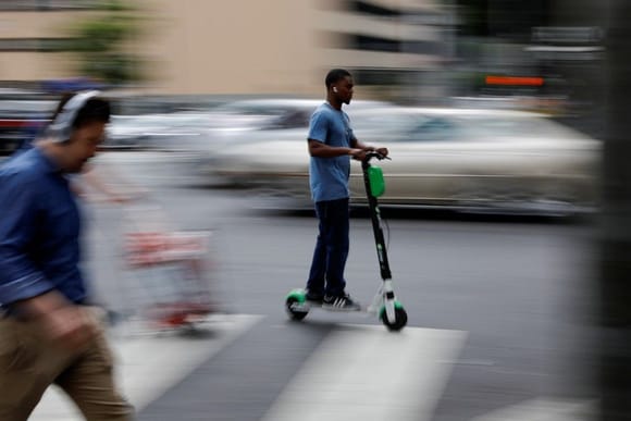 A man rides an electric scooter in Los Angeles. Mike Blake/Reuters