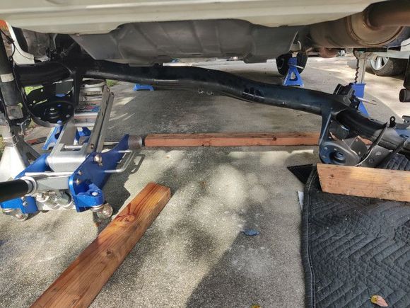 Use the jack and allow the bar to hang. Use a flashlight to look into the bolt hole. Your going to move the bar around till the bolt has a clear path.