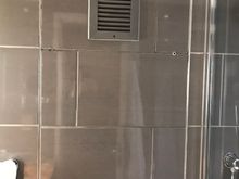 Cracked tiles on panel above toilet
