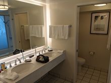 Double sink in the bathroom and a separate toilet area. The tile at the bottom and plumbing show signs of wear, as this was more of a cosmetic refresh than a full renovation.