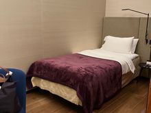 Twin bed with burgundy inflight blanket throw 