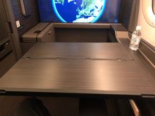 Got a picture of the tray table after everything was taken off. It's huge and has no problem fitting everything. It doesn't move during the meal; I'm skinny and was barely able to squeeze out to the side.