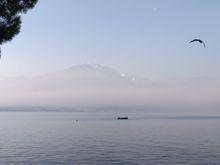Early morning in late January with a fisherman on the lake and the moon in the background 